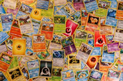 A vibrant banner displaying a variety of Pokémon cards, including booster packs, chase cards like Charizard and Umbreon VMAX, and Elite Trainer Boxes, showcasing the excitement of Pokémon TCG collecting.